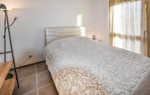 um quarto com uma cama com um edredão branco e uma janela em Nice Home In Le Pontet With Kitchen em Avignon