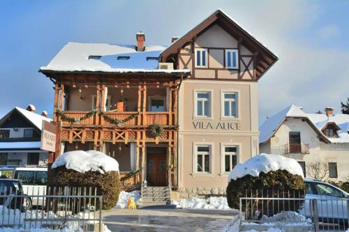 un bâtiment avec un panneau indiquant la mansarde dans la neige dans l'établissement Vila Alice Bled - Adults only, à Bled