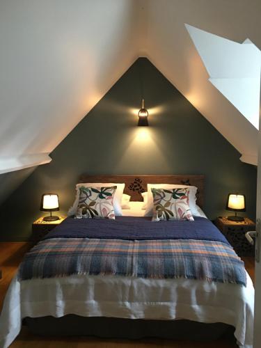 ein Schlafzimmer mit einem großen Bett mit zwei Lampen in der Unterkunft Après la pluie .... in Équemauville