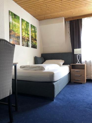 a bedroom with two beds and a desk and a window at Hotel Weismann in Sankt Georgen im Attergau