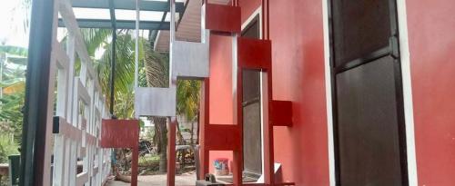 a red building with a mirror on the side of it at Affordable Staycation Home for 2-3 People! in Dauin