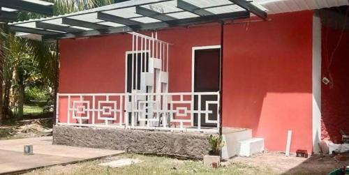 a red house with a painting on the side of it at Affordable Staycation Home for 2-3 People! in Dauin