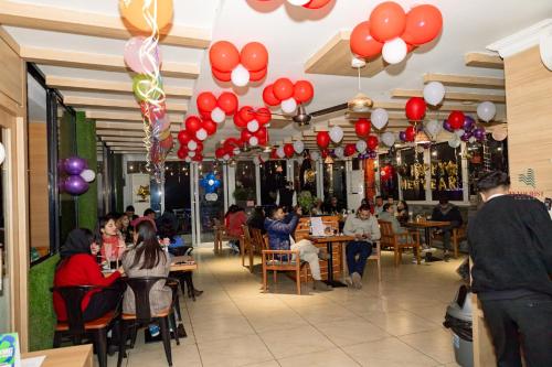 ein Restaurant mit roten und weißen Ballons, die von der Decke hängen in der Unterkunft Hotel Intourist Palace in Itahari