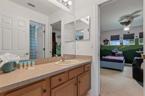 ein Badezimmer mit Waschbecken und Spiegel und ein Wohnzimmer in der Unterkunft Villa Eman 5bed 4bath with Private pool& Hot Tub close 2 Disney & Legoland in Haines City