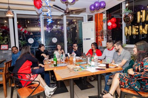 eine Gruppe von Menschen, die an einem Tisch in einem Restaurant sitzen in der Unterkunft Hotel Intourist Palace in Itahari