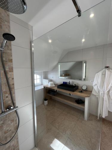 a bathroom with a sink and a shower with a mirror at Le Relais du Faget 
