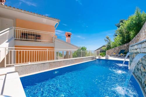 a swimming pool with a water feature in a house at Villa Pia in Brseč