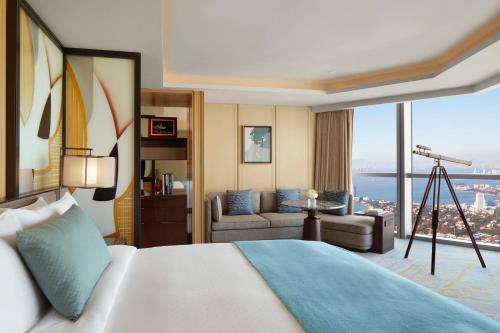 a hotel room with a large bed and a view at The St. Regis Qingdao in Qingdao