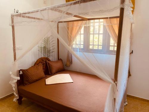 a bedroom with a canopy bed with a window at Dream Villa in Matara