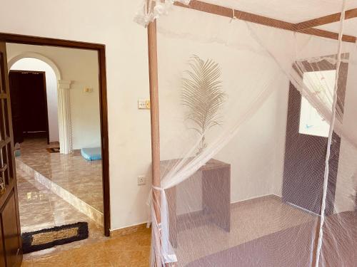 una stanza con una tenda sul muro e una stanza con una porta di Dream Villa a Matara