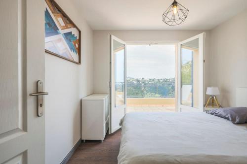 une chambre avec un lit et une grande fenêtre dans l'établissement Spacieuse Villa Niçoise au calme avec piscine, à Nice
