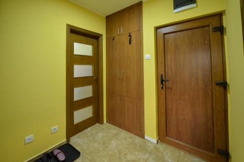 a hallway with two wooden doors in a room at Apartman Odzaci in Odžaci