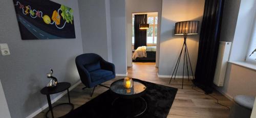 a living room with a blue chair and a table at Mastersuite in Bad Salzuflen