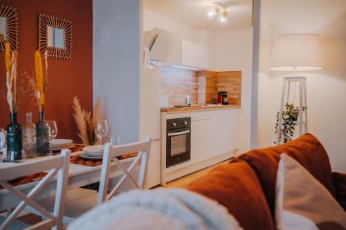 un salon avec un canapé et une table et une cuisine dans l'établissement L'Exilé • l'Oasis de tranquillité en Cœur de Ville, à Châteauroux