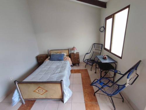 a bedroom with a bed and a table and chairs at Acogedora, independiente y tradicional Casa - Karapanza in Sucre