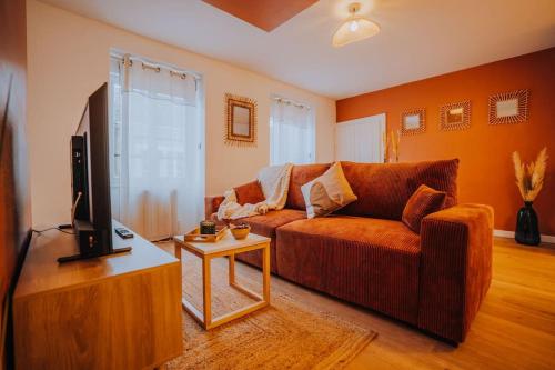 un salon avec un canapé et une télévision dans l'établissement L'Exilé • l'Oasis de tranquillité en Cœur de Ville, à Châteauroux