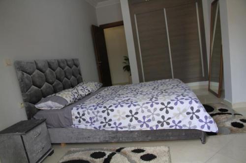 a bedroom with a bed with a purple and white comforter at Mahaj in Rabat