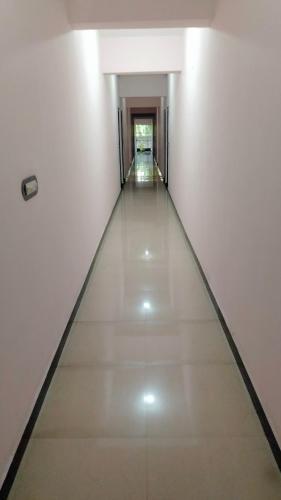 un lungo corridoio con pareti bianche e pavimenti bianchi di Shakthi Residency a Alleppey