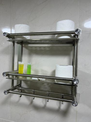a metal towel rack with toilet paper and two cups at Queen's Magic Camp in Wadi Rum