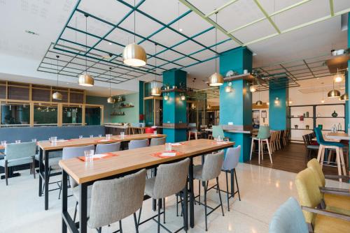 a restaurant with blue walls and tables and chairs at Ibis Casablanca City Center in Casablanca