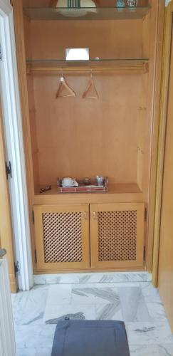 a wooden cabinet with a sink in a room at carmella in La Soukra