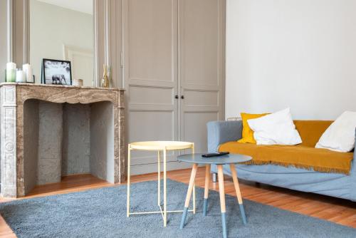 un salon avec un canapé et deux tables dans l'établissement Joli appartement une chambre en hypercentre, à Lille