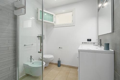 a white bathroom with a toilet and a sink at Villa Marconi Apartment 6 in Golfo Aranci