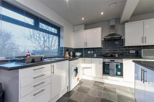 a kitchen with white cabinets and a dishwasher at Contractor-Friendly 3 Bed Home in Billingham in Norton