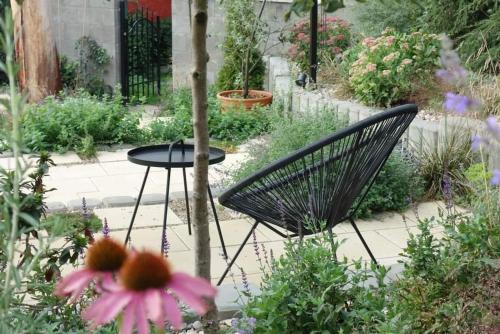 a black chair and a table in a garden at Hotel Restovna in Jíloviště