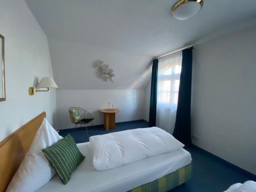 Schlafzimmer mit einem Bett, einem Fenster und einem Stuhl in der Unterkunft Gasthof Rössle Eberhardzell in Füramoos