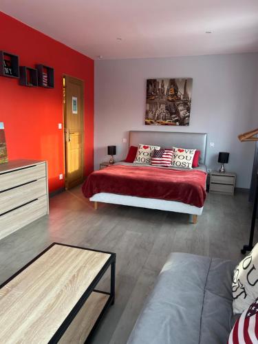 een slaapkamer met een bed en een rode muur bij Happy House St Cyp in Saint-Cyprien