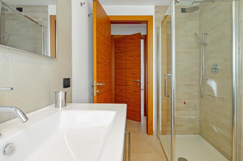 a bathroom with a sink and a shower and a glass door at Villa Marconi Apartment 7 in Golfo Aranci