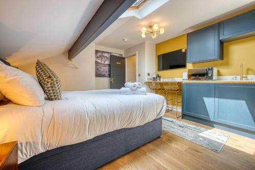 a bedroom with a large bed and a kitchen at Haworth Heights - An AMAZING Aparthotel! in Haworth