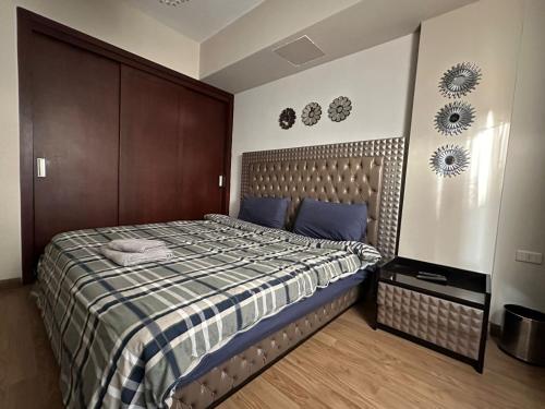 a bedroom with a bed with a brown headboard at Modern apartment in Cairo