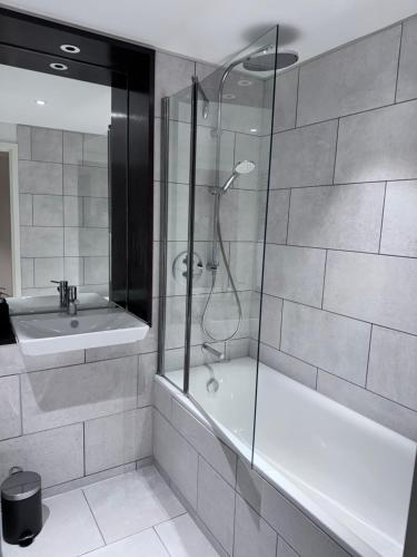 y baño con ducha, bañera y lavamanos. en Canning Town London Hub Aptmt, en Londres