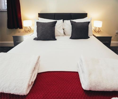 a large white bed with two pillows and two lamps at The Stay Company, Friar Gate Bridge. in Derby