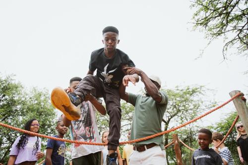 a young boy jumping over a rope obstacle at Matatane Camp - Babanango Game Reserve in Nkwalini