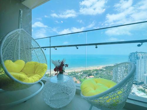 d'un balcon avec deux chaises et une vue sur l'océan. dans l'établissement The Sóng Apartment Vũng Tàu - Tabo Homestay, à Vung Tau