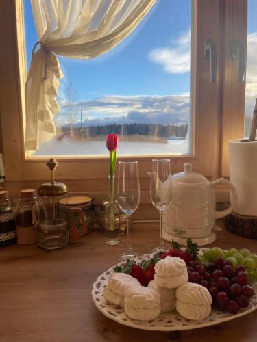 a plate of food on a table with a window at Ambercoast in Jūrmala