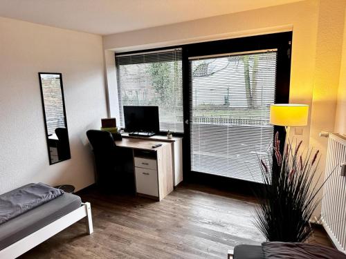 Zimmer mit einem Schreibtisch, einem Computer und einem Fenster in der Unterkunft Gemütliches & helles Doppelzimmer in Kleve in Kleve