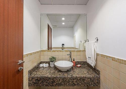baño con lavabo y espejo grande en Arabian Nights Beach Hostel, en Dubái