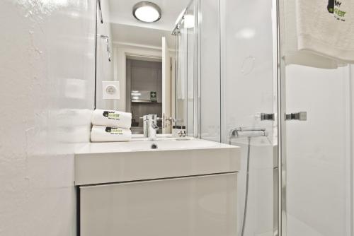 een witte badkamer met een wastafel en een spiegel bij BmyGuest - Lisbon Inner Bairro Alto in Lissabon