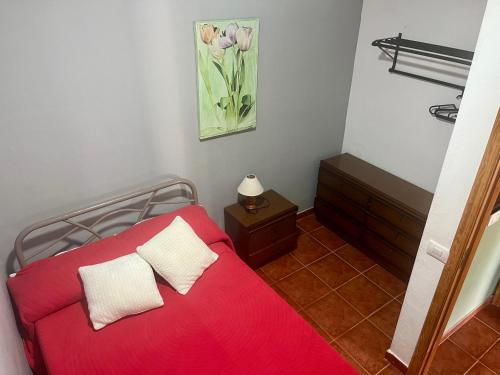 1 cama roja con 2 almohadas en una habitación en Casa Azul, en Vallehermoso