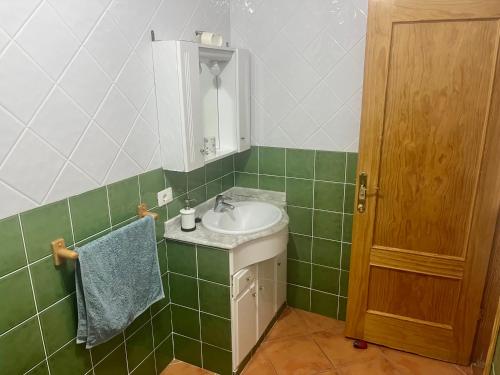 uma casa de banho verde e branca com um lavatório e um espelho em Casa Azul em Vallehermoso