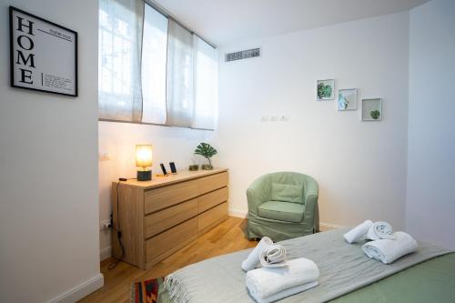 1 dormitorio con 2 camas, silla y ventana en Duomo in 10 minutes - Modern design close to Prada Foundation, en Milán