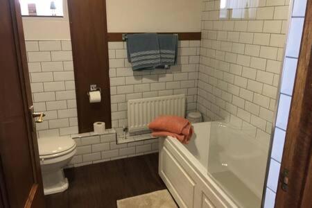 łazienka z wanną, toaletą i ręcznikami w obiekcie LetAway - Captain Cook's Cottage, Staithes w mieście Staithes