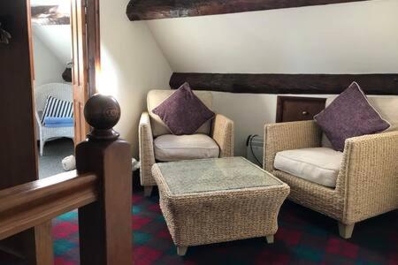 salon z 2 krzesłami i stołem w obiekcie LetAway - Captain Cook's Cottage, Staithes w mieście Staithes