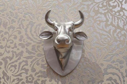a metal bull mask hanging on a wall at Hotel Peterhof - urban lifestyle Kempten in Kempten