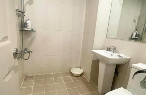 a white bathroom with a sink and a toilet at Namhangang Park Motel in Chungju