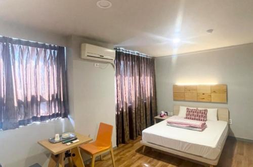 忠州的住宿－Namhangang Park Motel，卧室配有1张床、1张桌子和1把椅子